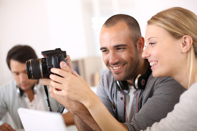 A man and woman looking at a camera.